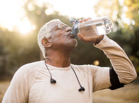 A senior African American Man enjoying refreshing water after a workout