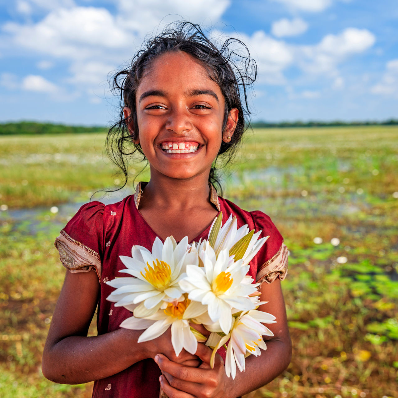 Happy child holds a bunch of daisies.
