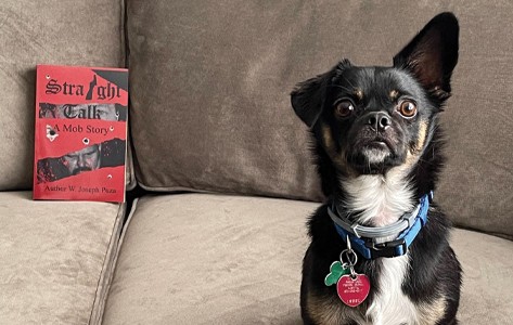 Newton Medical Center patient W. Joseph Puza's book and pet dog sit on a couch.