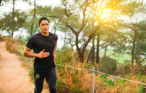 Man running on path in woods