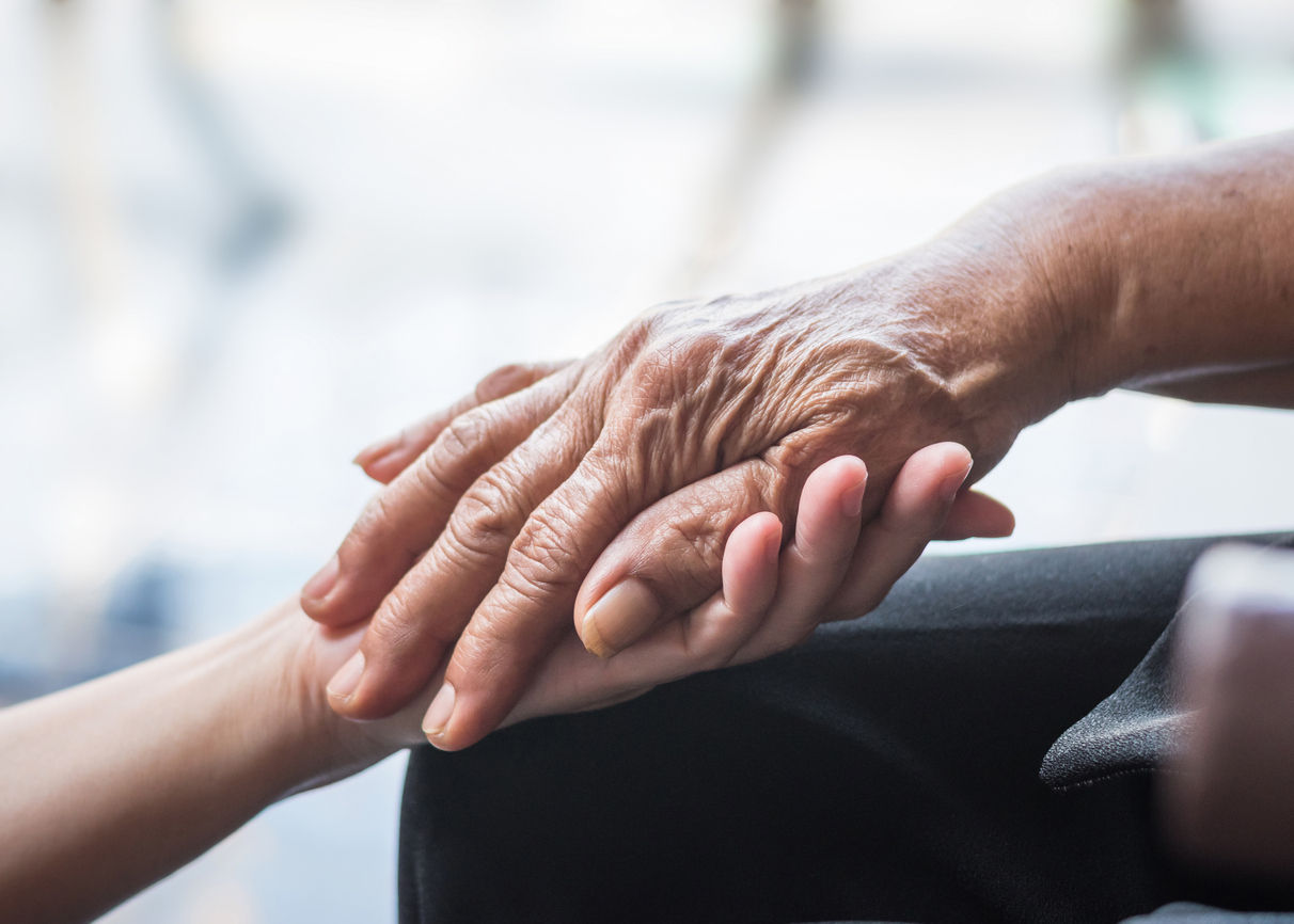 Elderly and young hand, clasped.