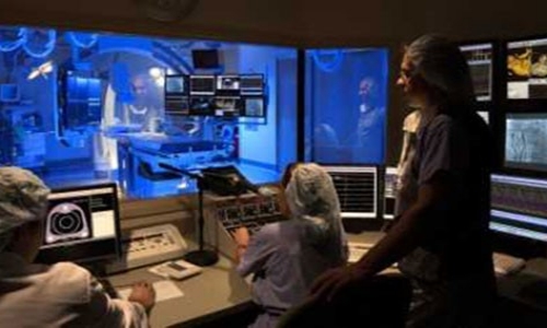Doctors examine patient undergoing cardiac diagnostic services.