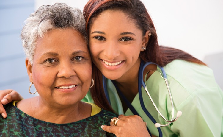 Nurse hugs older female patient