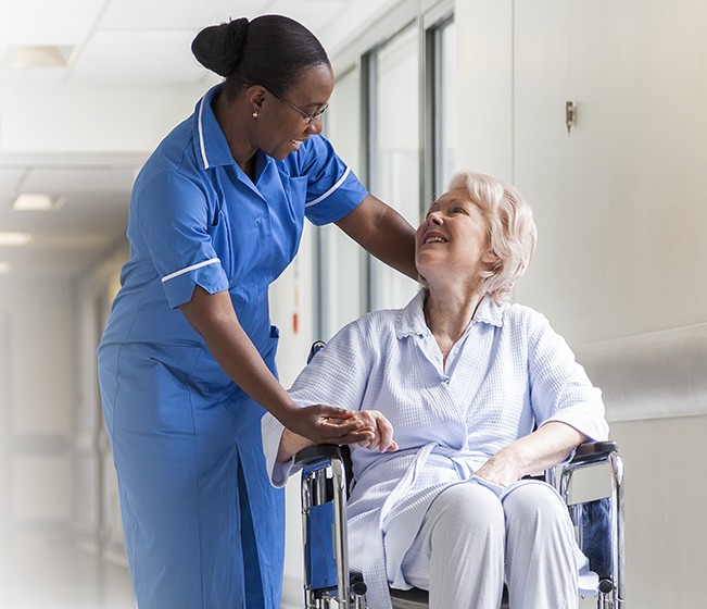 Hospital orderly assists woman in wheelchair