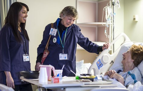 Hospital volunteers visit patient's bedside